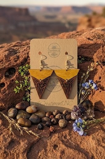 Handmade wood earrings displayed among red rocks